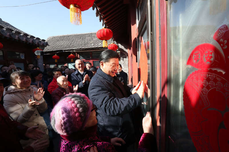 2019年2月1日上午，習近平在北京前門(mén)東區草廠(chǎng)四條胡同32號院，高興地拿起一幅“?！弊?，親自貼到門(mén)上，給這里的老街坊們拜年。新華社記者 鞠鵬 攝