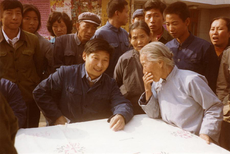 1983年，時(shí)任河北正定縣委書(shū)記的習近平（前排居中），臨時(shí)在大街上擺桌子聽(tīng)取老百姓意見(jiàn)。
